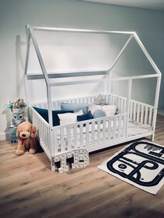 a doll house bed with a teddy bear next to it