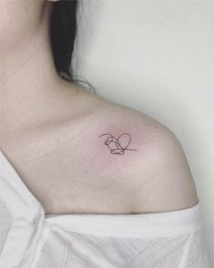 a woman's shoulder with a small tattoo on the left side of her chest