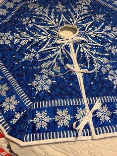 a blue and white quilt with snowflakes on it, tied to the edge