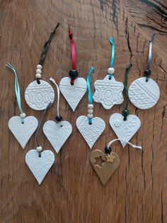 white ceramic heart ornaments with ribbons on wooden table top, set of 6 ornament