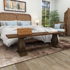 a large bed sitting on top of a wooden floor next to a table and chair