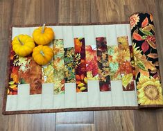 a quilted table runner with fall leaves and pumpkins