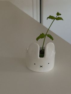 a plant in a white bunny shaped vase