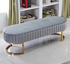 a bench sitting on top of a white floor next to a book shelf filled with books