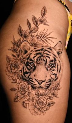 a woman's thigh with a tiger and flowers on it