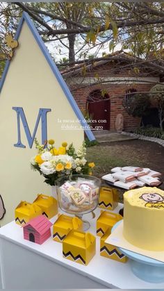 a table topped with cakes and cupcakes next to a sign that says m