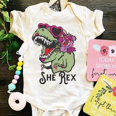 "GIRL T- REX! (DINOSAUR) BODYSUIT: Designed and handmade in Phoenix. Hear me ROAR! She Rex is dressed up and out on the town with her girlie accents but make no mistake about it, she's tough. This is the perfect girlie dinosaur tee, with a retro twist. This listing is for (ONE) \"GIRL T- REX\" Bodysuit ★CURRENT PROMOTIONS! ★ >Keep an eye out for our 20% off flash sale! We run it randomly, so be sure to keep checking back! >When sale is running, add items to your cart and the discount will Boho Dinosaur, Dino Nursery, Baby Shower Announcement, Dinosaur Tee, Hear Me Roar, Girl Dinosaur, Pink Dinosaur, Perfect Girl