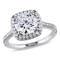 a cushion cut diamond ring with double halos on the sides and pave set shoulders