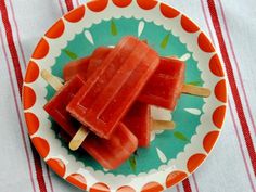 watermelon pops on a plate with a striped tablecloth