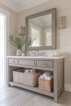 a bathroom vanity with two baskets under the sink and a mirror on the wall above it