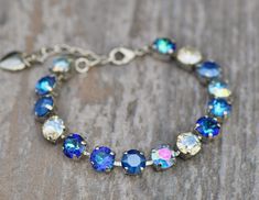 A gorgeous new bracelet made with Swarovski crystal. The bracelet features 8mm crystals ranging in color from royal blue de lite, royal blue, aqua transmission, crystal moonlight, and bermuda blue color. Crystals are hand set into a premium bracelet setting, and prong set. Bracelet will adjust to fit wrist sizes 6 inches and up. Please choose desired metal finish at checkout. Shown in silver in images above. ** Nickel and lead free Adjustable Blue Bracelets With Sparkling Stones, Blue Faceted Crystal Bracelets, Blue Crystal Bracelet With Sparkling Stones, Blue Crystal Bracelet With Rhinestones, Adjustable Blue Crystal Rhinestone Bracelet, Adjustable Blue Crystal Bracelet With Rhinestones, Blue Crystal Bracelet, Set Bracelet, Stacked Necklaces