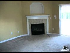 an empty living room with a fireplace and sliding glass doors