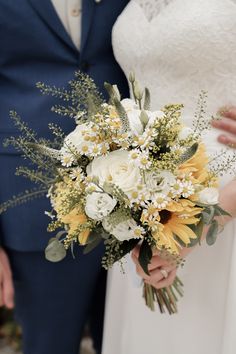 the bride and groom are holding their wedding bouquet