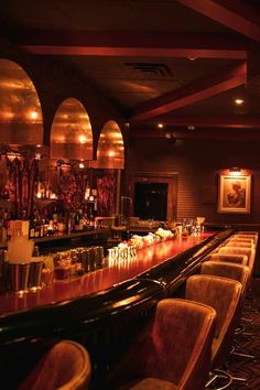 a dimly lit bar with chairs and lights