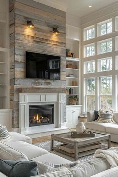 a living room filled with furniture and a flat screen tv mounted on the wall above a fire place