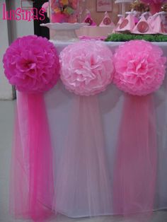 pink and white flowers are on display at a baby's first birthday cake table