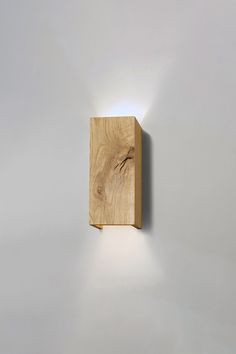 a wooden object is mounted on the wall with a light coming from it's side