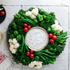 broccoli, cauliflower and other vegetables arranged in a wreath on a table