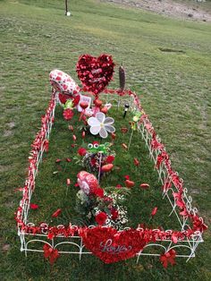 a valentine's day display in the grass with flowers and hearts