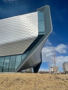 an unusual building is shown against the blue sky with white clouds in the back ground