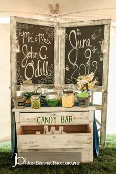 an outdoor dessert bar with chalkboard signs