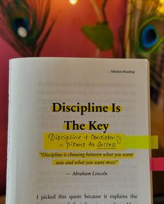 an open book with the words discipline is the key written in yellow and black on it