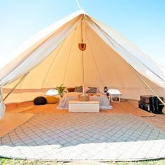 the inside of a large tent with lots of furniture