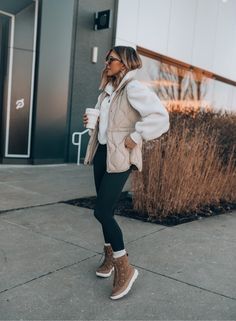 a woman in black leggings and a white jacket