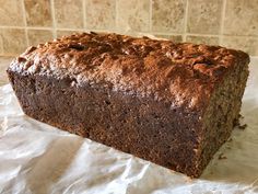 a loaf of chocolate cake sitting on top of white paper