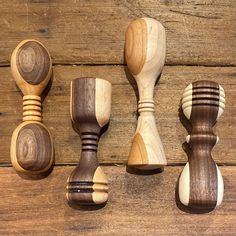 four wooden spoons are lined up on a table