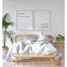 there is a bed with two pictures on the wall above it and a plant next to it