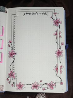 an open notebook with pink flowers on it