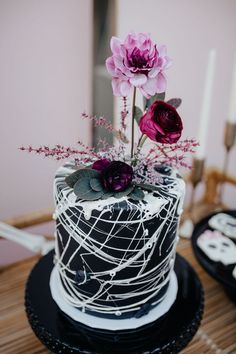 there is a black and white cake with flowers on the top, along with other decorations