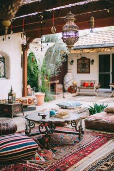 an outdoor living area with lots of furniture and rugs