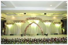 the stage is decorated with flowers and greenery