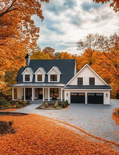 a large white house surrounded by fall leaves