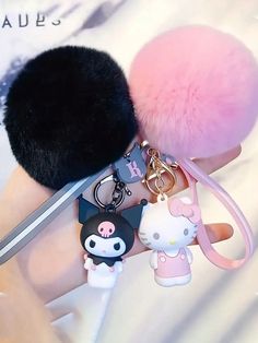 the key chain is attached to an animal - shaped bag charm with a pink pom - pom on it