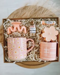 a pink box containing two coffee mugs, tea and other items with flowers on them