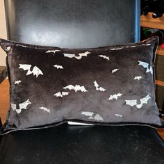 a black and white pillow with bats on it