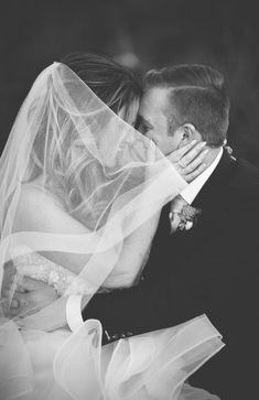 a bride and groom kissing under the veil