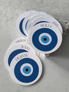 four blue and white coasters with the words dearne on them sitting on a marble surface