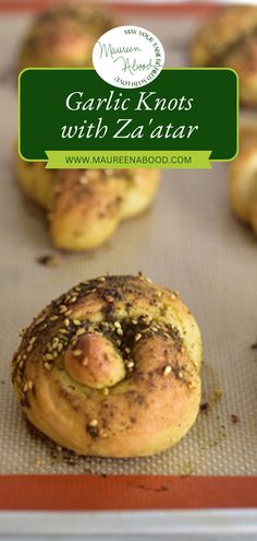 garlic knots with zaatar on a baking sheet in the middle of muffins