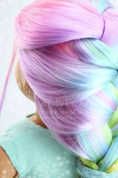 a doll with pink, blue and green hair is wearing a braided hairstyle