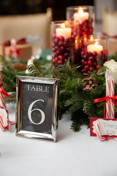 the table is set with candles, candy canes and place cards for christmas dinner