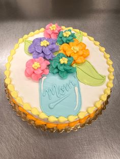 a cake decorated with flowers and the word mom on it