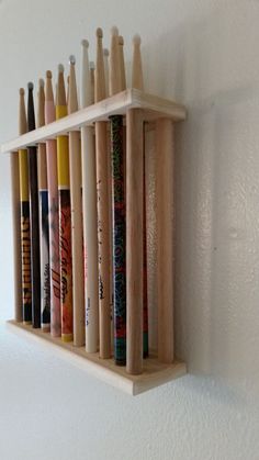 a wooden rack with baseball bats mounted to it's side on the wall next to a white wall