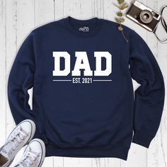 Custom Dad Sweatshirt, New Dad Sweatshirt, Custom Sweatshirt, Custom Dad Shirt, Dad Est Shirt, Father's Day Shirt, Dada Sweatshirt. Our products are Bella+Canvas branded. If Bella+Canvas is out of stock, I will send it from a trusted brand of the same size and quality. You can contact us in case of any problem or request. If you purchase a custom product, I will send you a message to confirm the design, don't forget to check your message box. Your satisfaction is important to us :) Please check the size chart before purchase products. We do not accept returns or exchanges on the products unless there is a mistake or damage caused by us. Please make sure that you get the right size for yourself by looking at the size chart before purchasing the products. We do not accept exchange and return Father's Day Long Sleeve Relaxed Fit Sweatshirt, Father's Day Long Sleeve Letter Print T-shirt, Father's Day Long Sleeve T-shirt With Letter Print, Long Sleeve T-shirt With Letter Print For Father's Day, White Long Sleeve T-shirt For Father's Day, Father's Day Casual Sweatshirt With Name Print, Father's Day Cotton Crew Neck Sweatshirt, Father's Day Cotton Sweatshirt With Name Print, Casual Crew Neck Tops For Father's Day