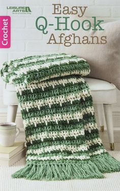 a green and white afghan sitting on top of a chair