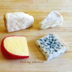 four pieces of bread with different colors and shapes on a wooden surface, including one piece of bread