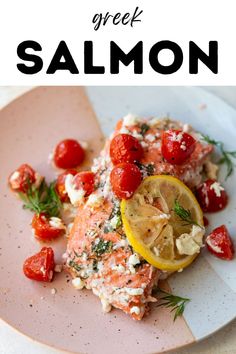 salmon with lemon and tomatoes on a pink plate